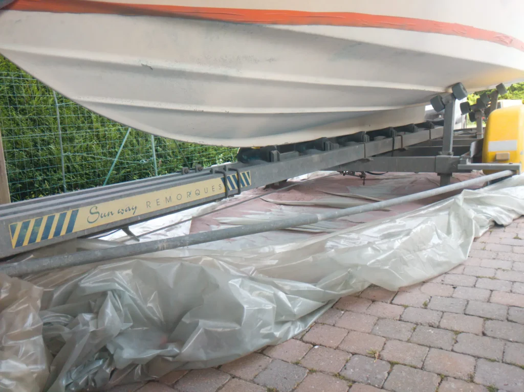 Coque bateau fibre de verre décapage antifouling aérogommage en cours surface assainie Belgique