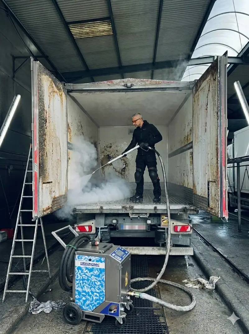 Technicien Surface Reborn effectuant un nettoyage cryogénique au CO₂ à l'intérieur d'un camion frigorifique