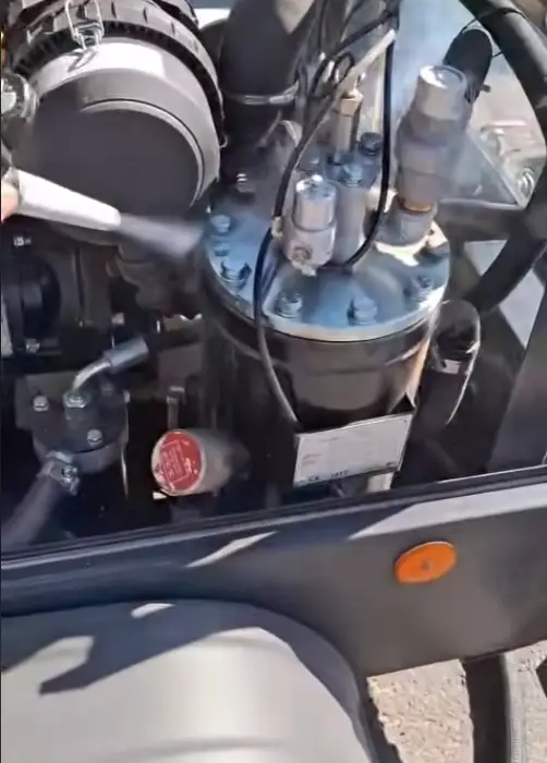 Vue rapprochée en plongée des composants internes en acier d'un nettoyeur cryogénique industriel, montrant les tuyaux et le réservoir sur une machine agricole.
